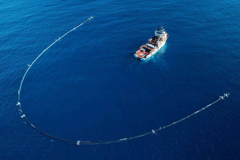 Dispositif de collecte de déchets flottants tracté par des navires en mer.
